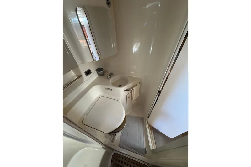 Slide: The Image of 2002 Sea Ray 380 Sundancer bathroom with toilet, sink, and mirror. - 32
