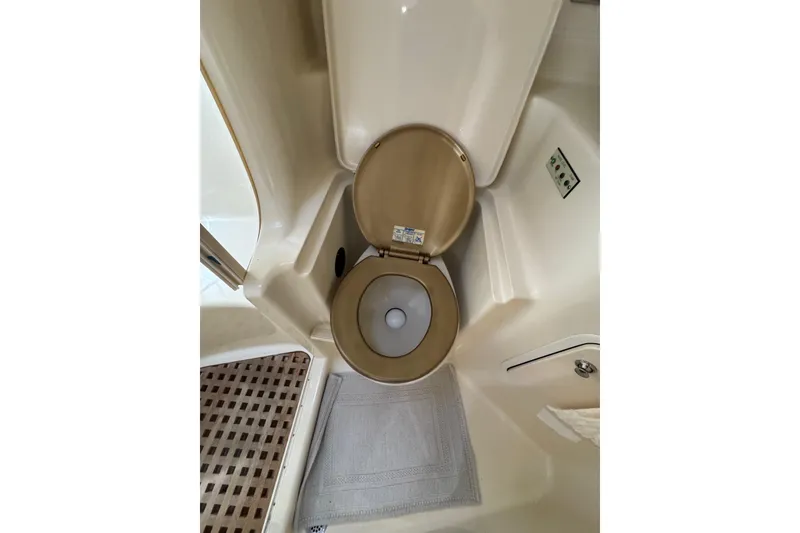 Slide: The Image of 2002 Sea Ray 380 Sundancer bathroom with beige toilet and mat. - 33