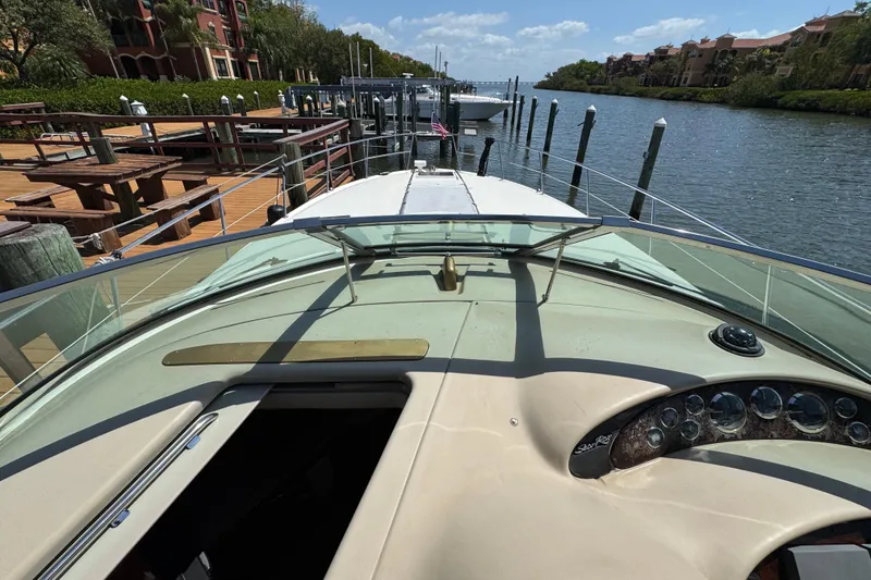 Slide: The Image of 2002 Sea Ray 380 Sundancer yacht docked by a scenic waterfront. - 36