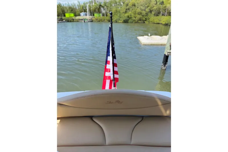 Slide: The Image of 2002 Sea Ray 380 Sundancer boat with American flag on calm water. - 38