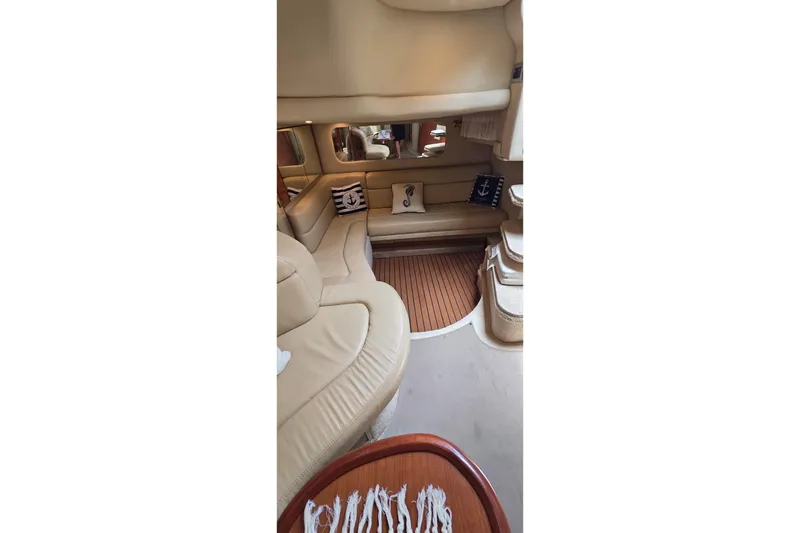 Slide: The Image of Luxurious interior of 2002 Sea Ray 380 Sundancer yacht with beige seating and nautical decor. - 59