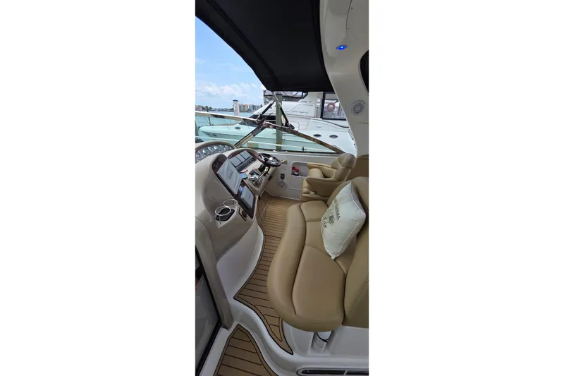Slide: The Image of Interior view of 2002 Sea Ray 380 Sundancer yacht cockpit with tan seating and controls. - 61