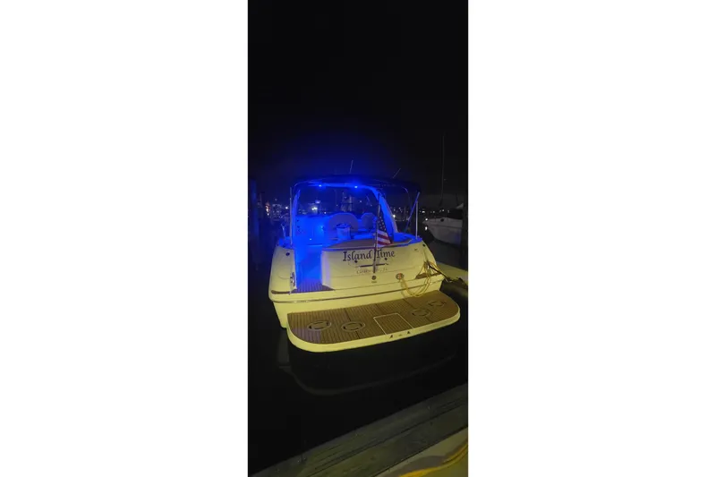 Slide: The Image of 2002 Sea Ray 380 Sundancer yacht illuminated with blue lights at night. - 70