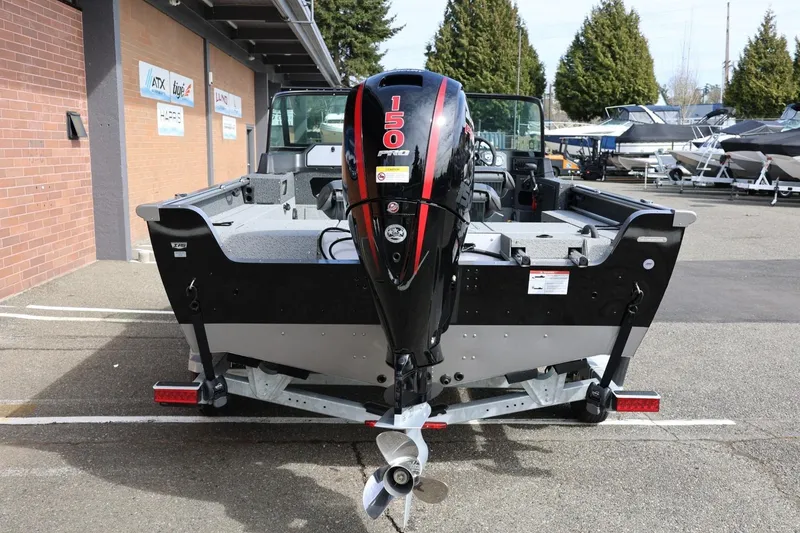 Slide: The Image of 2026 Lund 1875 Impact XS Sport boat with 150 HP engine, parked outdoors. - 11
