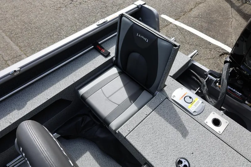 Slide: The Image of 2026 Lund 1875 Impact XS Sport boat interior with gray seating and storage compartments. - 23