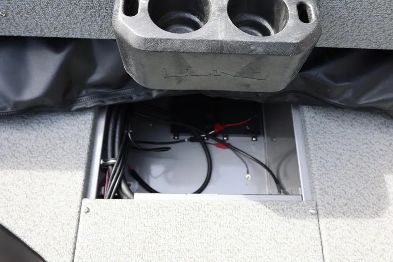 Slide: The Image of Interior view of 2026 Lund 1875 Impact XS Sport boat, featuring storage compartment and cup holders. - 31