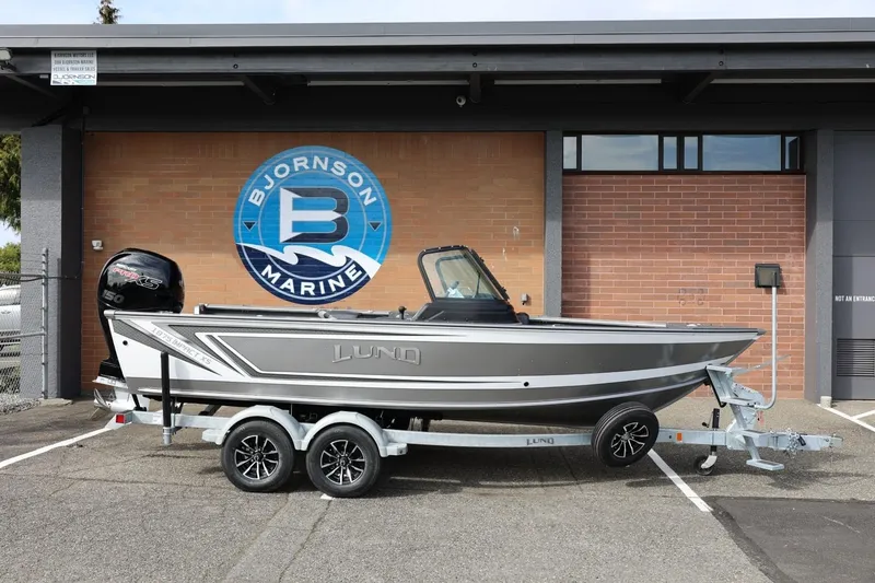 The Image of 2026 Lund 1875 Impact XS Sport boat on trailer at Bjornson Marine. - 1