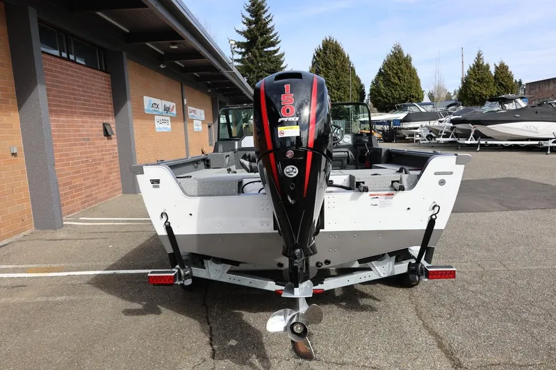 Slide: The Image of 2026 Lund 1875 Impact XS Sport boat with powerful outboard motor in a dealership lot. - 11