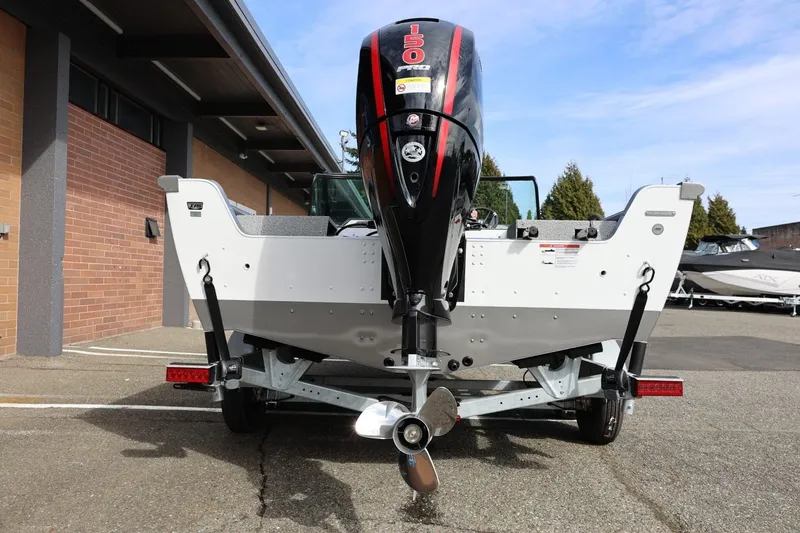 Slide: The Image of 2026 Lund 1875 Impact XS Sport boat with powerful outboard motor, parked outdoors. - 12
