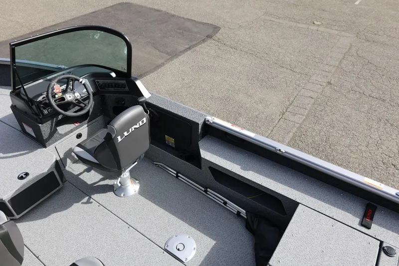 Slide: The Image of 2026 Lund 1875 Impact XS Sport boat interior with steering wheel and seating. - 19