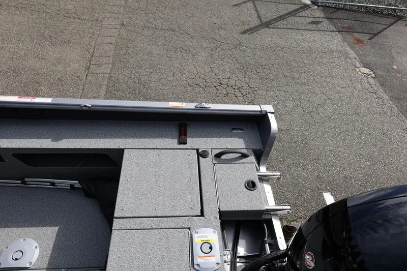 Slide: The Image of 2026 Lund 1875 Impact XS Sport boat interior with storage compartments and motor. - 20