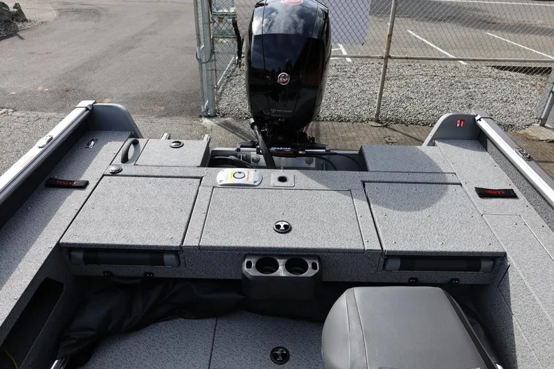 Slide: The Image of 2026 Lund 1875 Impact XS Sport boat interior with motor, storage compartments, and seating. - 21