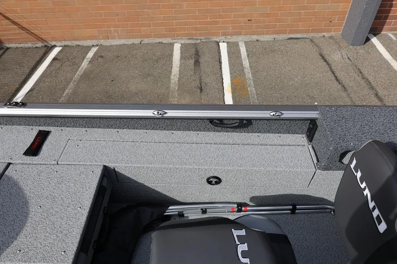 Slide: The Image of 2026 Lund 1875 Impact XS Sport boat interior with gray flooring and branded seating. - 25