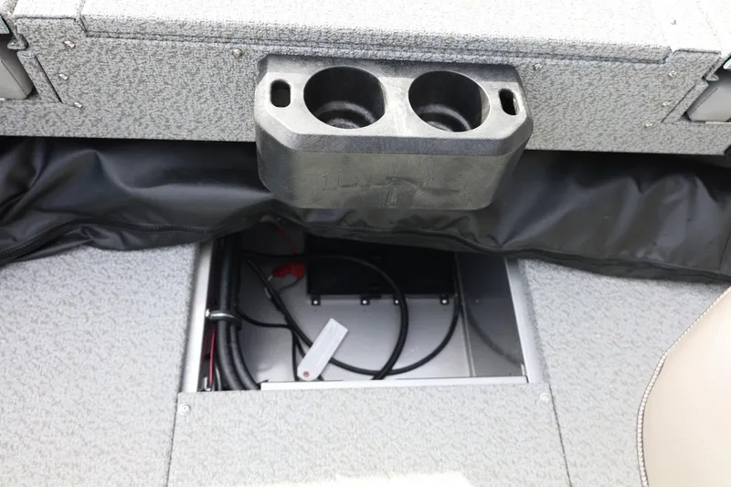 Slide: The Image of 2026 Lund 1875 Impact XS Sport boat interior with cup holders and storage compartment. - 28