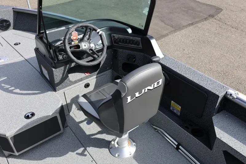 Slide: The Image of 2026 Lund 1875 Impact XS Sport boat interior with steering wheel and seat. - 30