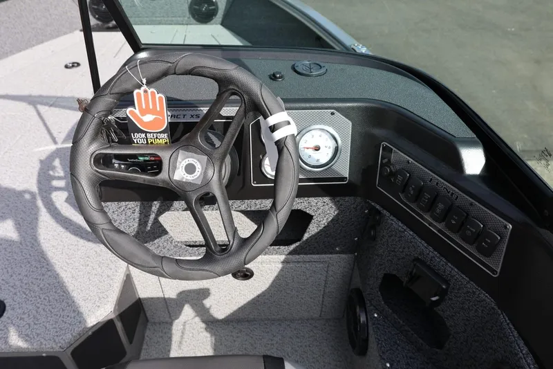 Slide: The Image of Steering wheel of 2026 Lund 1875 Impact XS Sport boat with dashboard controls. - 31