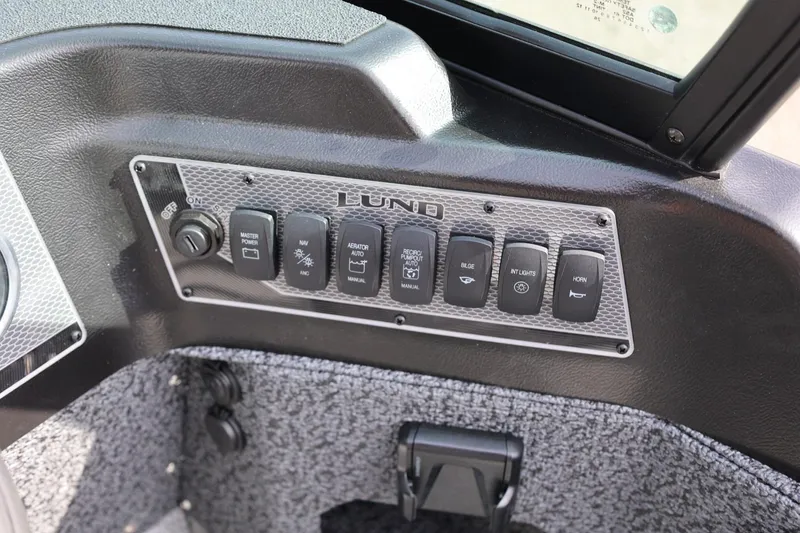 Slide: The Image of Control panel of 2026 Lund 1875 Impact XS Sport boat with various switches. - 32