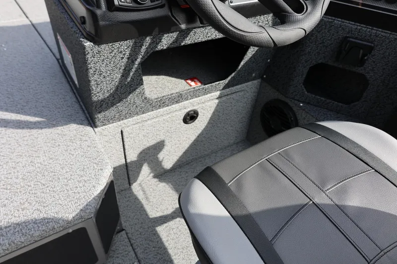 Slide: The Image of Interior of 2026 Lund 1875 Impact XS Sport boat, featuring steering wheel and seat. - 34