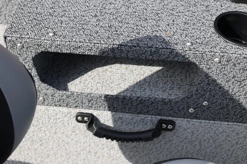 Slide: The Image of Interior detail of 2026 Lund 1875 Impact XS Sport boat, featuring textured gray surface and handle. - 37