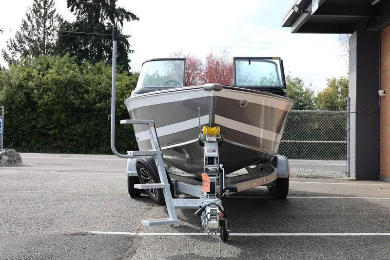 Slide: The Image of 2026 Lund 1875 Impact XS Sport boat on trailer, parked outdoors. - 6