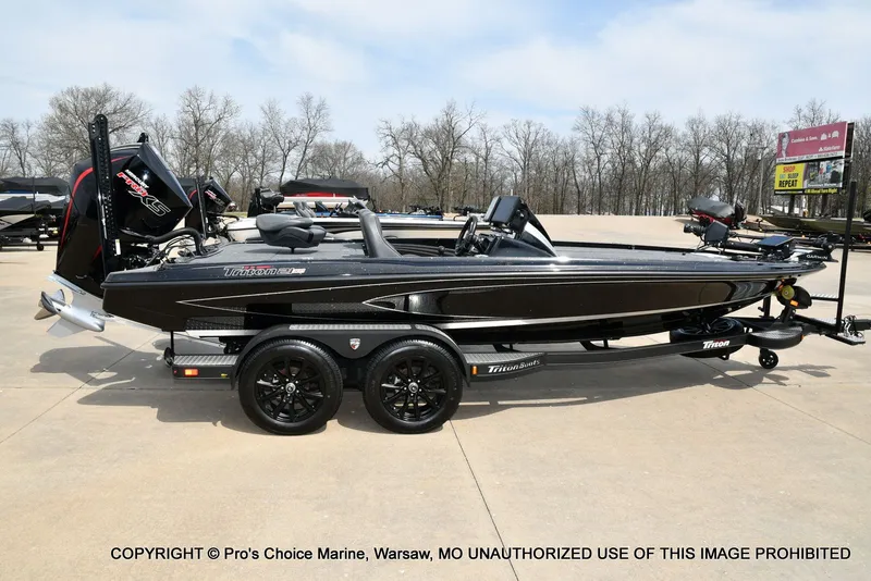 Slide: The Image of Black 2025 Triton 21XP boat on trailer outdoors. - 22