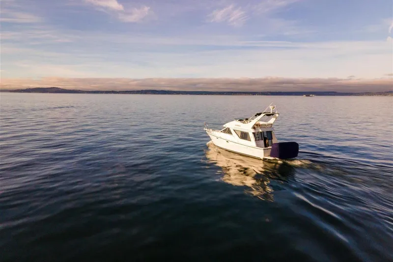 Slide: The Image of 2002 Bayliner 3988 Command Bridge Motoryacht cruising on calm waters under a clear sky. - 1