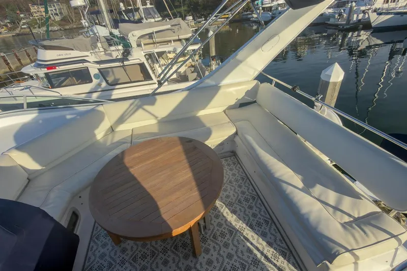 Slide: The Image of 2002 Bayliner 3988 Command Bridge Motoryacht with spacious seating and wooden table on deck. - 11