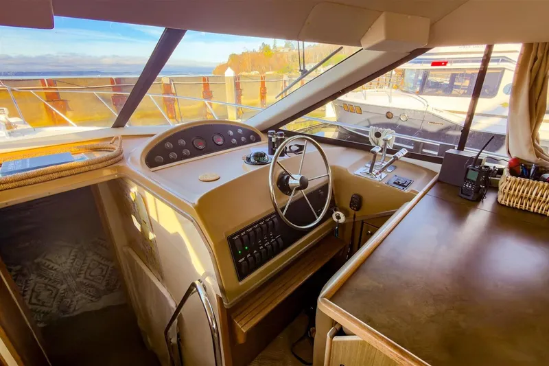 Slide: The Image of 2002 Bayliner 3988 Command Bridge Motoryacht helm with steering wheel and control panel. - 19