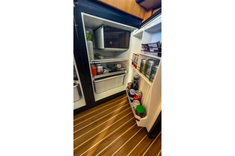Slide: The Image of Open refrigerator inside 2002 Bayliner 3988 Command Bridge Motoryacht, stocked with beverages and food. - 22