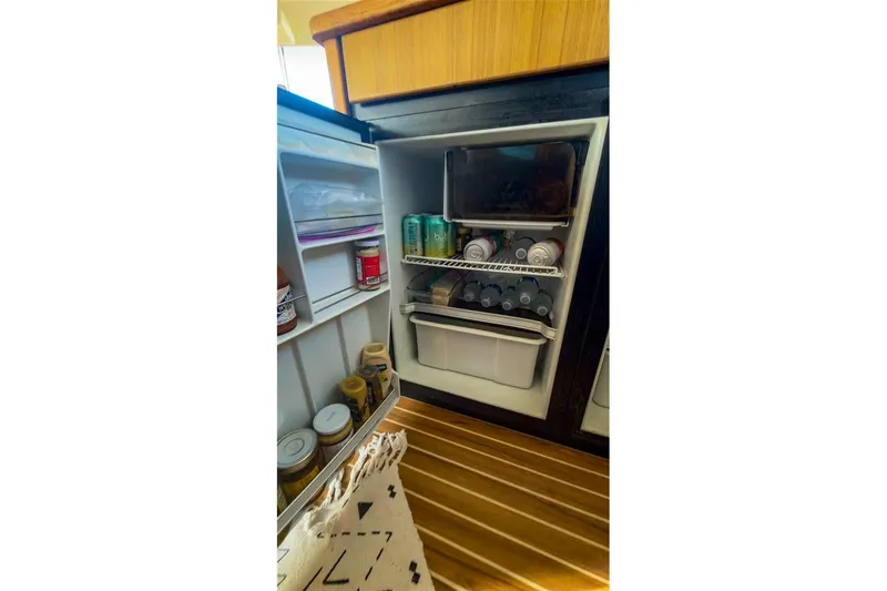 Slide: The Image of Open fridge inside 2002 Bayliner 3988 Command Bridge Motoryacht, stocked with drinks and condiments. - 23