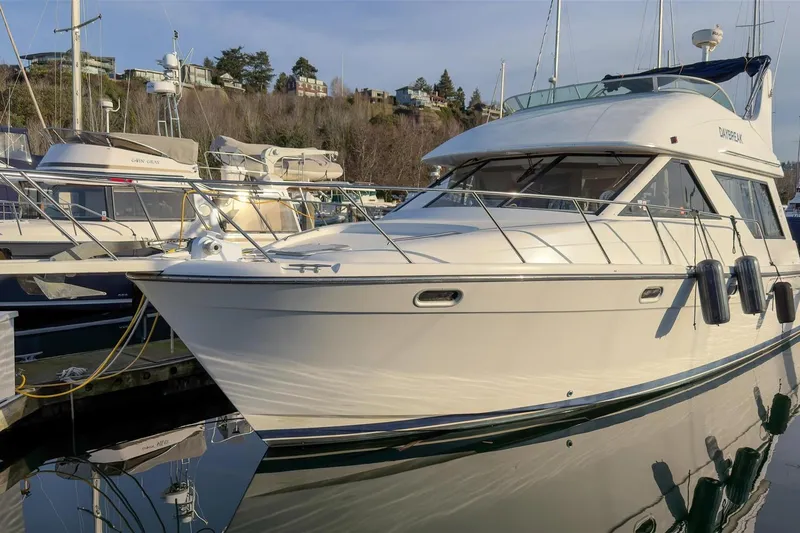 Slide: The Image of 2002 Bayliner 3988 Command Bridge Motoryacht docked at marina, reflecting on water. - 4