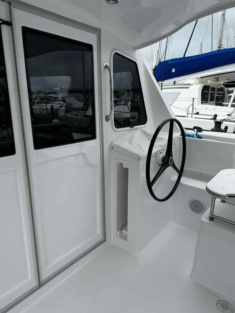 Slide: The Image of 2023 Seawind 1160 Lite yacht cockpit with steering wheel and windows. - 11