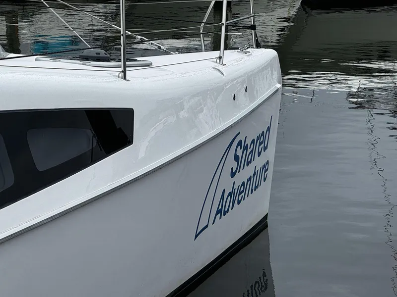Slide: The Image of Seawind 1160 Lite 2023 catamaran named Shared Adventure docked in calm waters. - 2