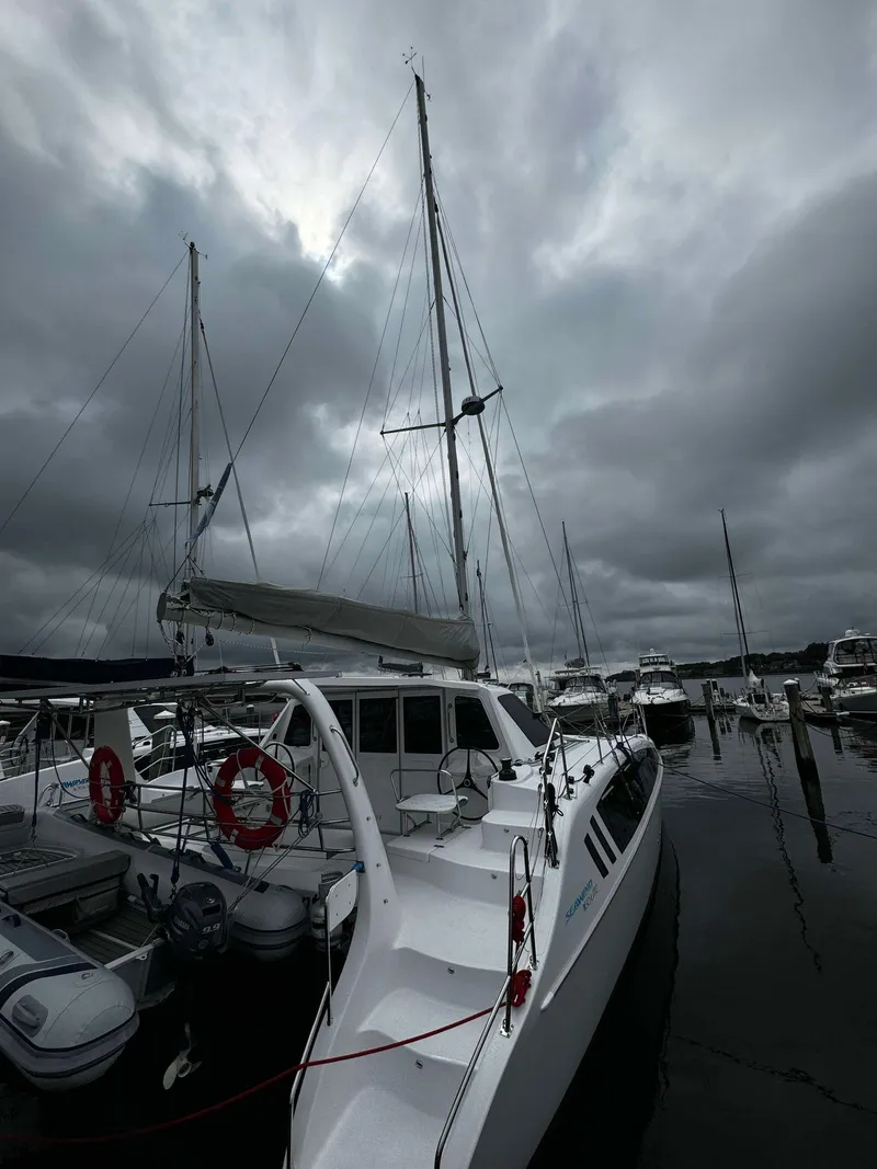 Slide: The Image of 2023 Seawind 1160 Lite catamaran docked at a marina under cloudy skies. - 7