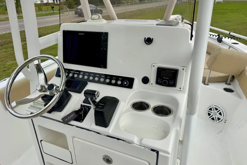 Slide: The Image of 2016 Sea Hunt Ultra 234 boat console with steering wheel and electronic controls. - 13