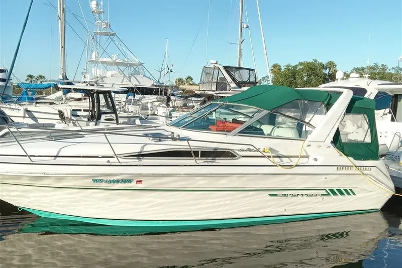 The Image of 1993 Sea Ray 290 Sundancer boat docked in a marina with green canopy. - 0