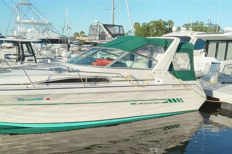 Slide: The Image of 1993 Sea Ray 290 Sundancer boat docked at marina with green canopy. - 10