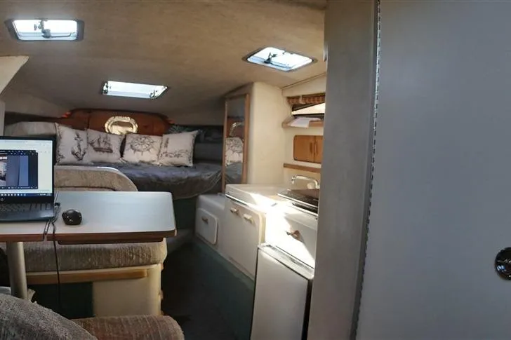 Slide: The Image of Interior of a 1993 Sea Ray 290 Sundancer boat with cozy seating and kitchenette. - 13