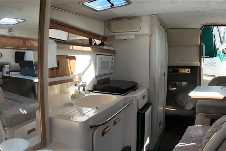 Slide: The Image of Interior of 1993 Sea Ray 290 Sundancer boat with kitchenette and seating area. - 17