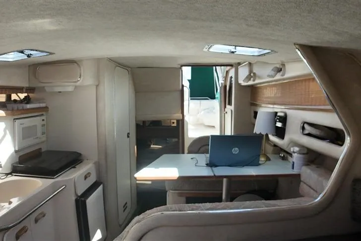 Slide: The Image of Interior of 1993 Sea Ray 290 Sundancer boat with kitchenette and seating area. - 18