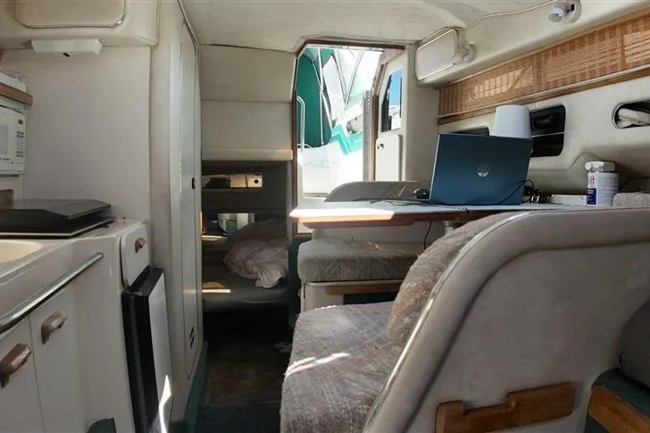 Slide: The Image of Interior of a 1993 Sea Ray 290 Sundancer boat with seating and a laptop on the table. - 19