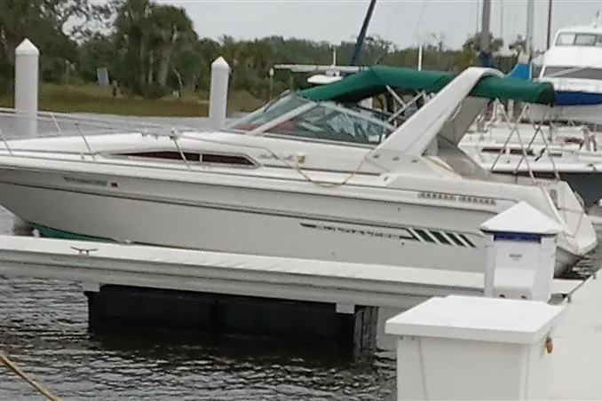 Slide: The Image of 1993 Sea Ray 290 Sundancer docked at a marina with green canopy. - 2