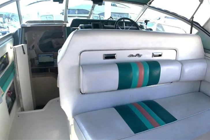 Slide: The Image of 1993 Sea Ray 290 Sundancer interior with teal and pink-accented seating. - 22
