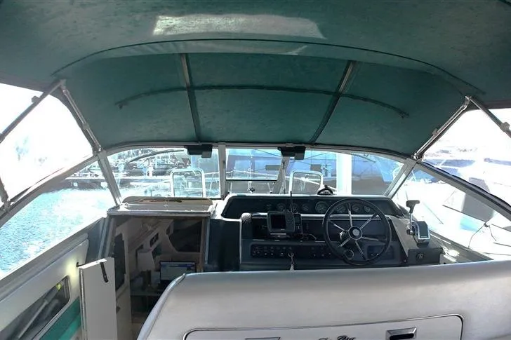 Slide: The Image of Cockpit view of a 1993 Sea Ray 290 Sundancer boat with steering wheel and dashboard. - 26