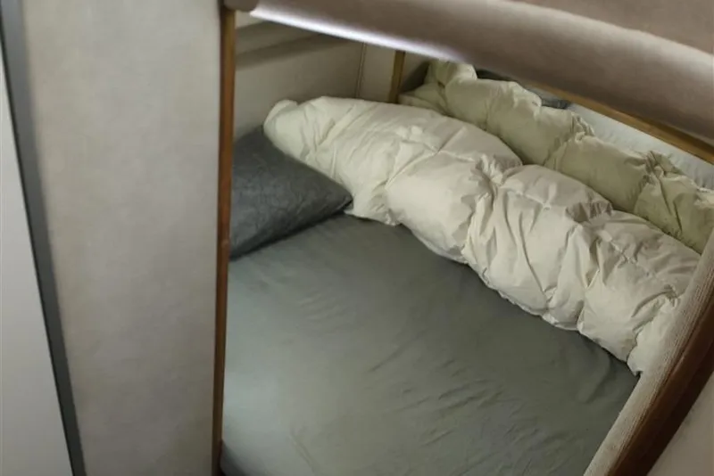 Slide: The Image of Cozy cabin bed inside a 1993 Sea Ray 290 Sundancer boat. - 30
