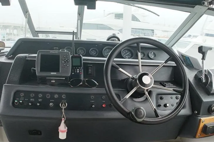 Slide: The Image of 1993 Sea Ray 290 Sundancer helm with steering wheel and navigation instruments. - 31