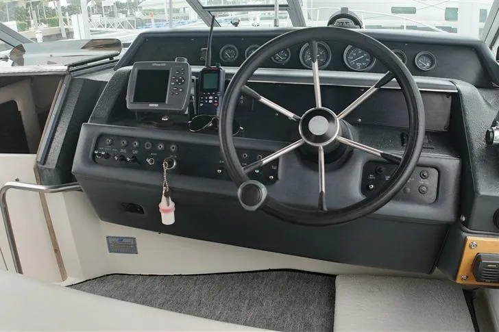 Slide: The Image of 1993 Sea Ray 290 Sundancer helm with steering wheel, gauges, and navigation equipment. - 32