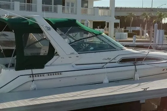 Slide: The Image of 1993 Sea Ray 290 Sundancer boat docked with green canopy. - 8