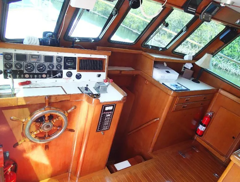 Slide: The Image of 1987 Tayana 45 Expedition Trawler helm with wooden interior and navigation instruments. - 11
