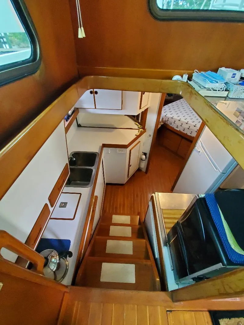 Slide: The Image of Interior of 1987 Tayana 45 Expedition Trawler with wooden cabinetry and compact kitchen area. - 14